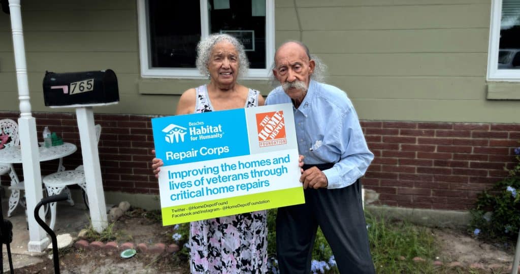 Senior Couple holding repair program sign